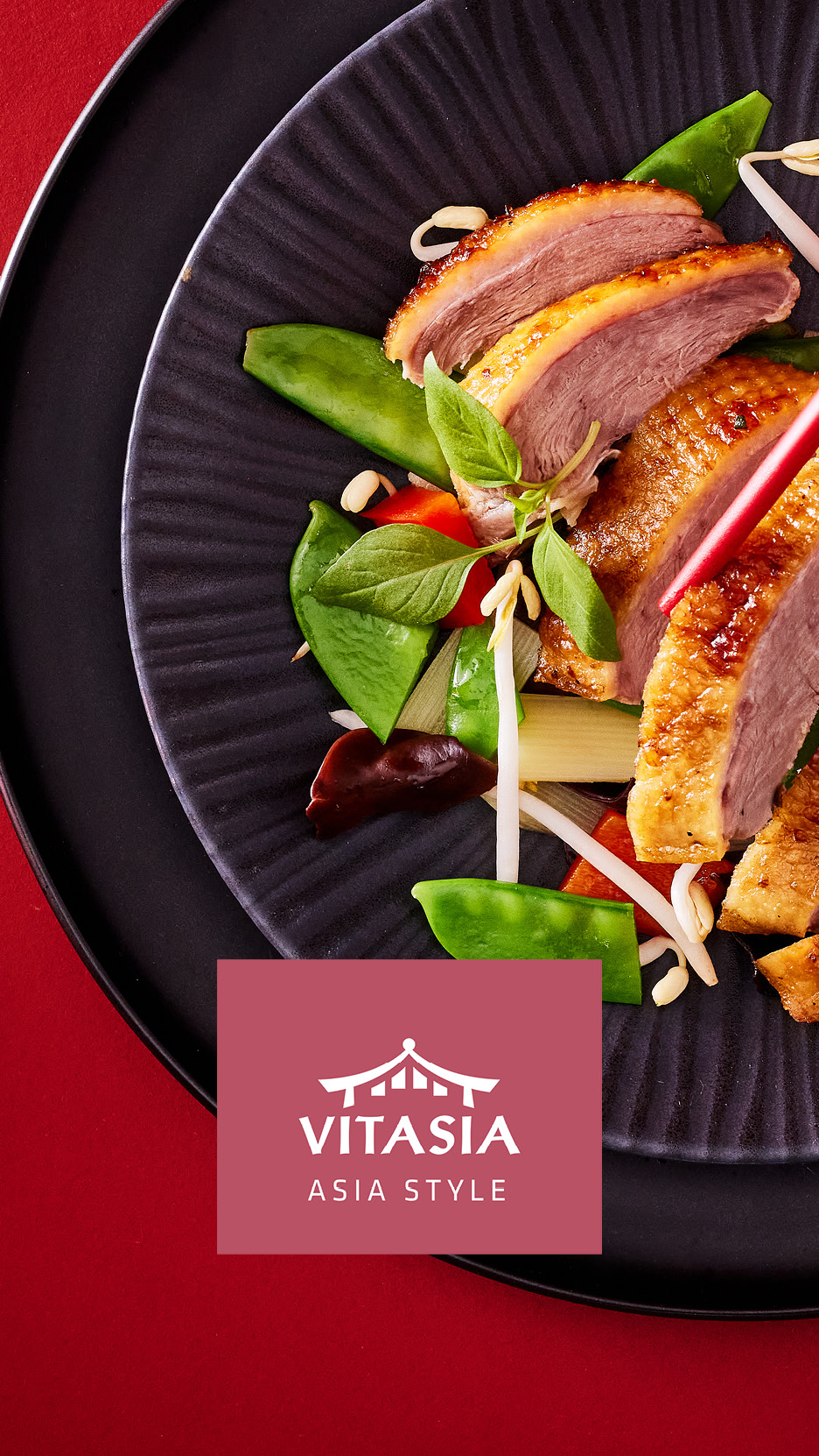 Anatra asiatica con verdure fresche e germogli di soia su un piatto nero.