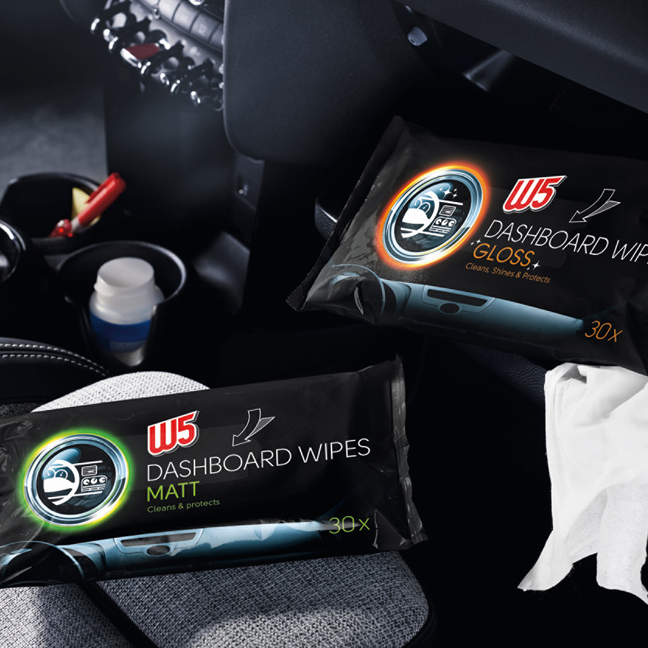 Salviette per cruscotto opache e lucide in un'auto, con una salvietta bianca estratta.